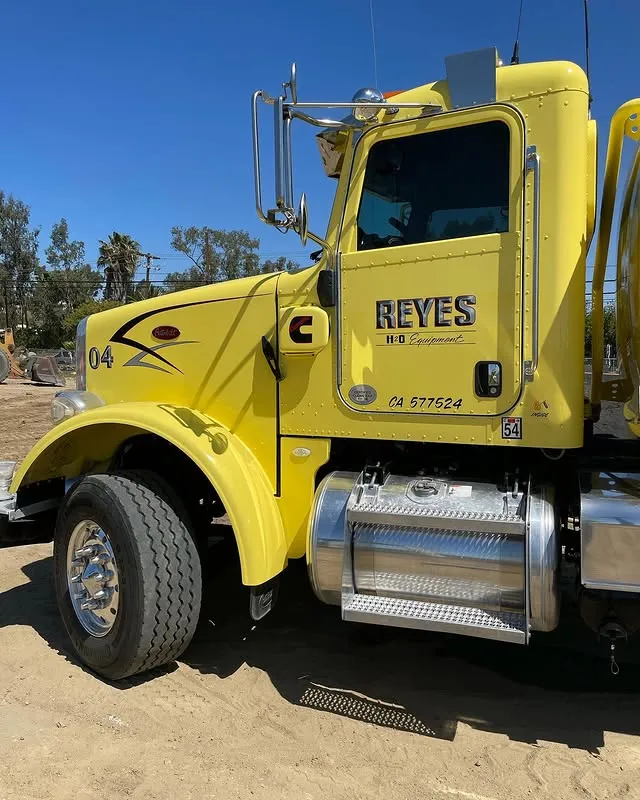 Yellow water truck with the logo "Reyes H2O Equipment" on the side door.