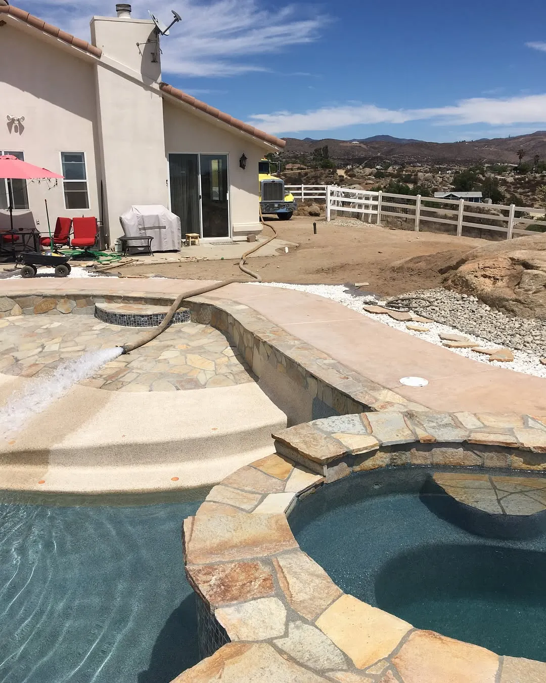 Backyard pool in the middle of a warm sunny day.