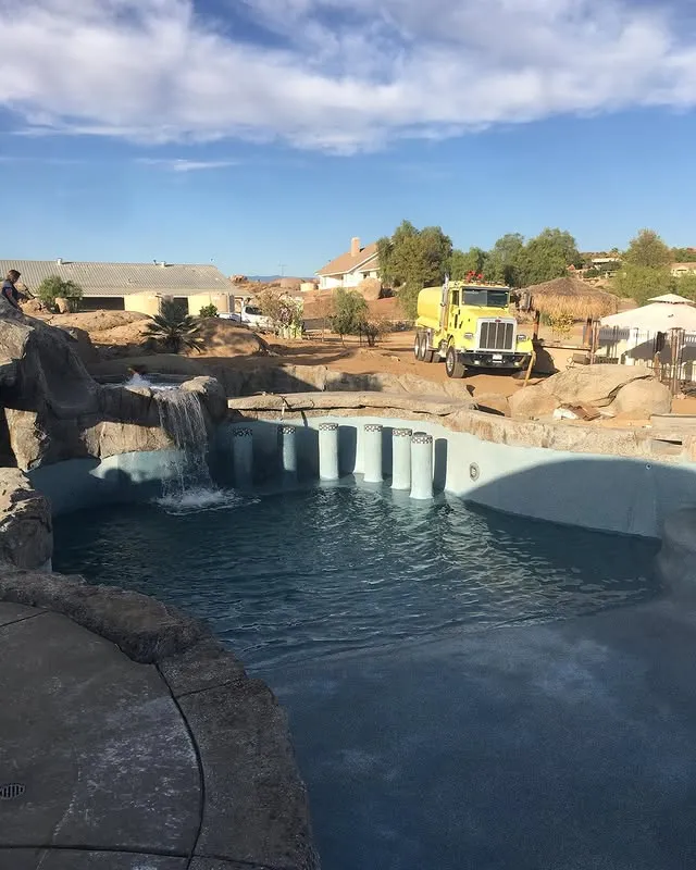 Yellow truck parked next to a pool.